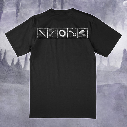 A black short-sleeve t-shirt shown from the back, featuring a white graphic print of four square panels containing a sword, a pipe, a ring, and a mushroom. The shirt is displayed against a moody, misty gray background.