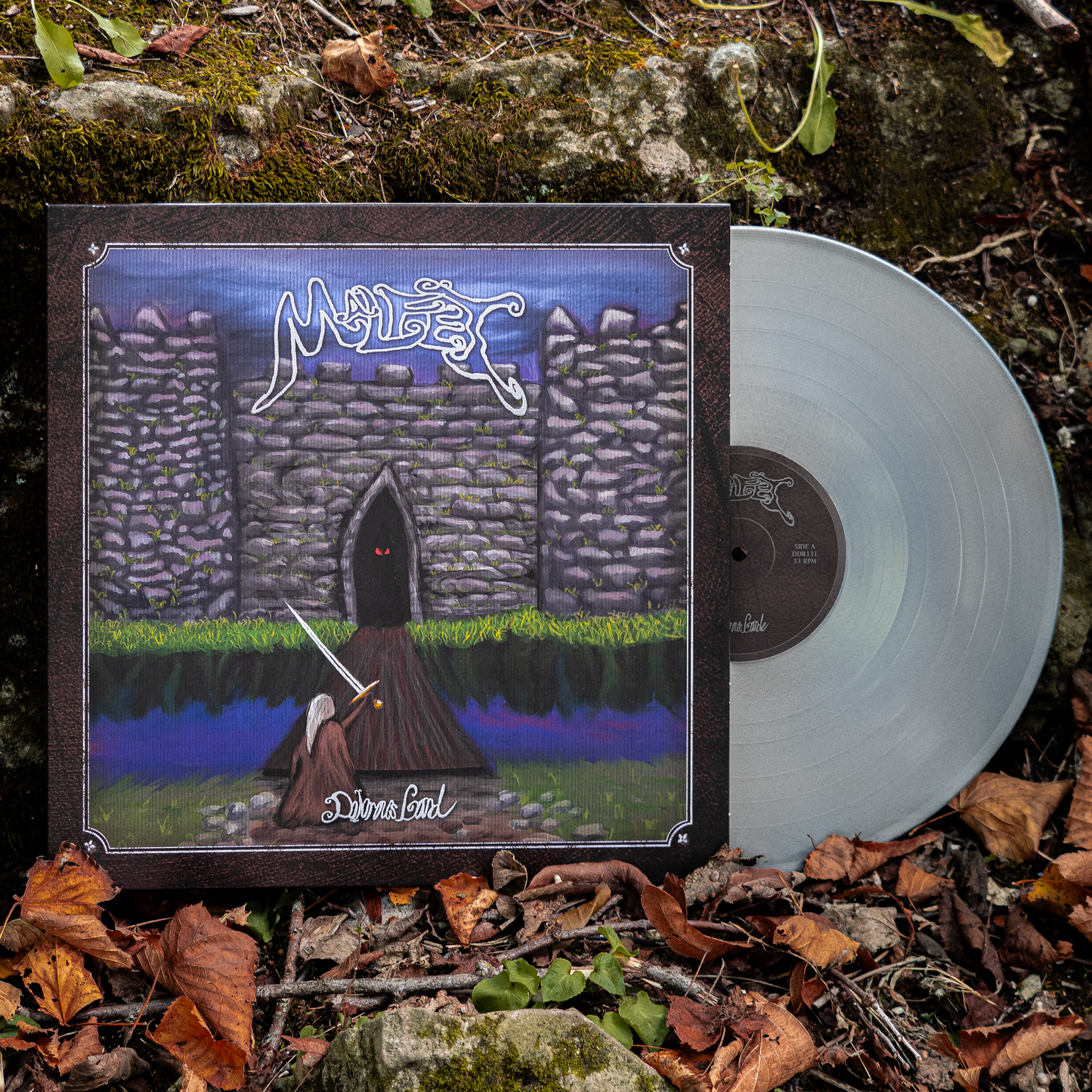 A vinyl record titled 'Malfet - Dolorous Gard' with an illustration of a dark, medieval-themed scene on the cover, featuring a castle and a figure with a sword. The vinyl color is metallic silver.