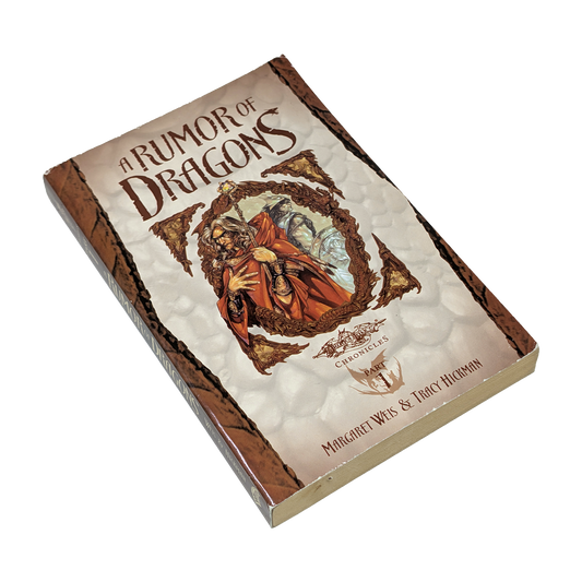 A boxed book or boxed set titled "A Rumor of Dragons" shown at an angle on a plain white background. The front cover features fantasy artwork with a robed figure in red and orange tones, and the spine/border appears brown with textured cream panels.