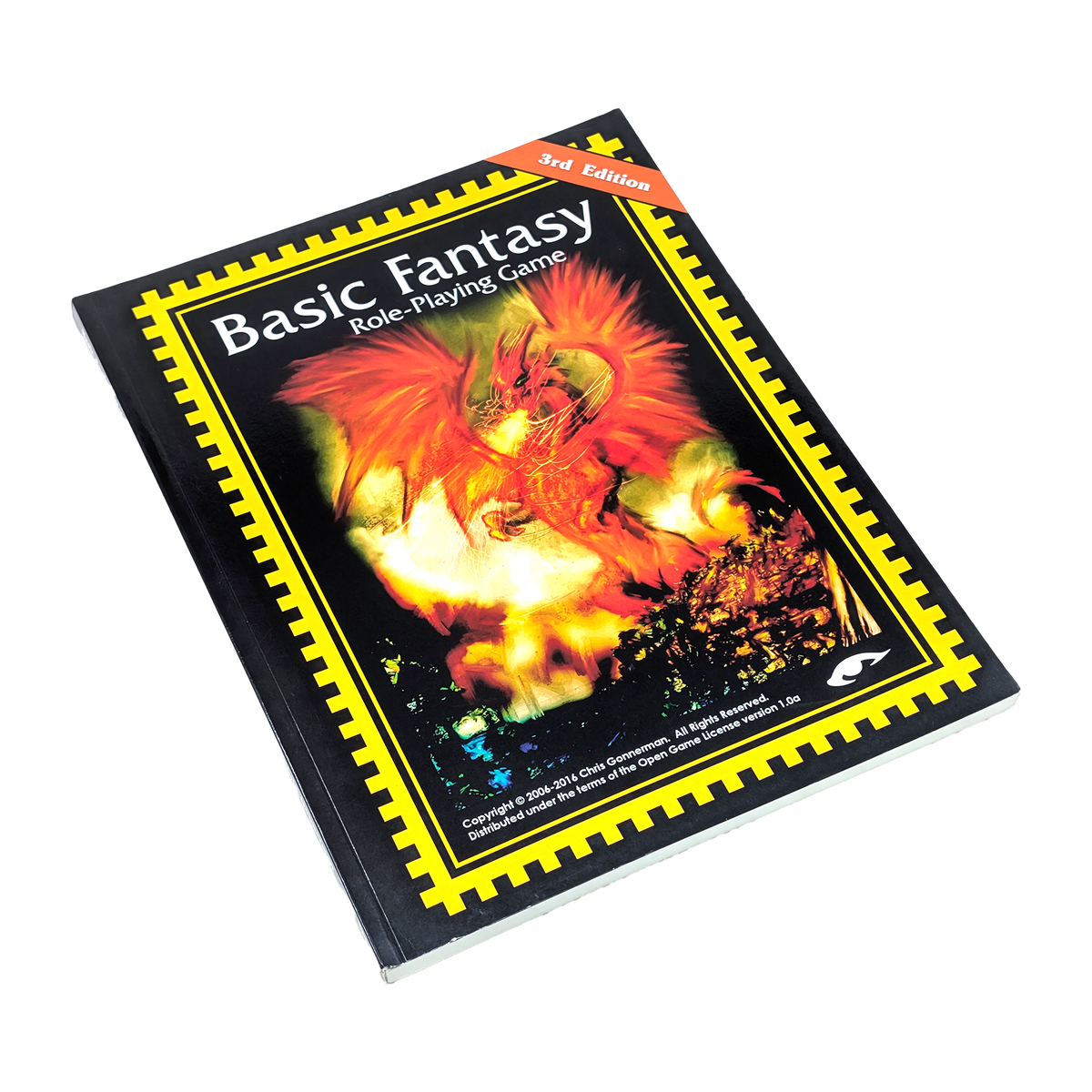 Basic Fantasy Role-Playing Game 3rd Edition book cover, featuring a fiery red and orange dragon illustration on a black background with a yellow border, photographed on a white background.