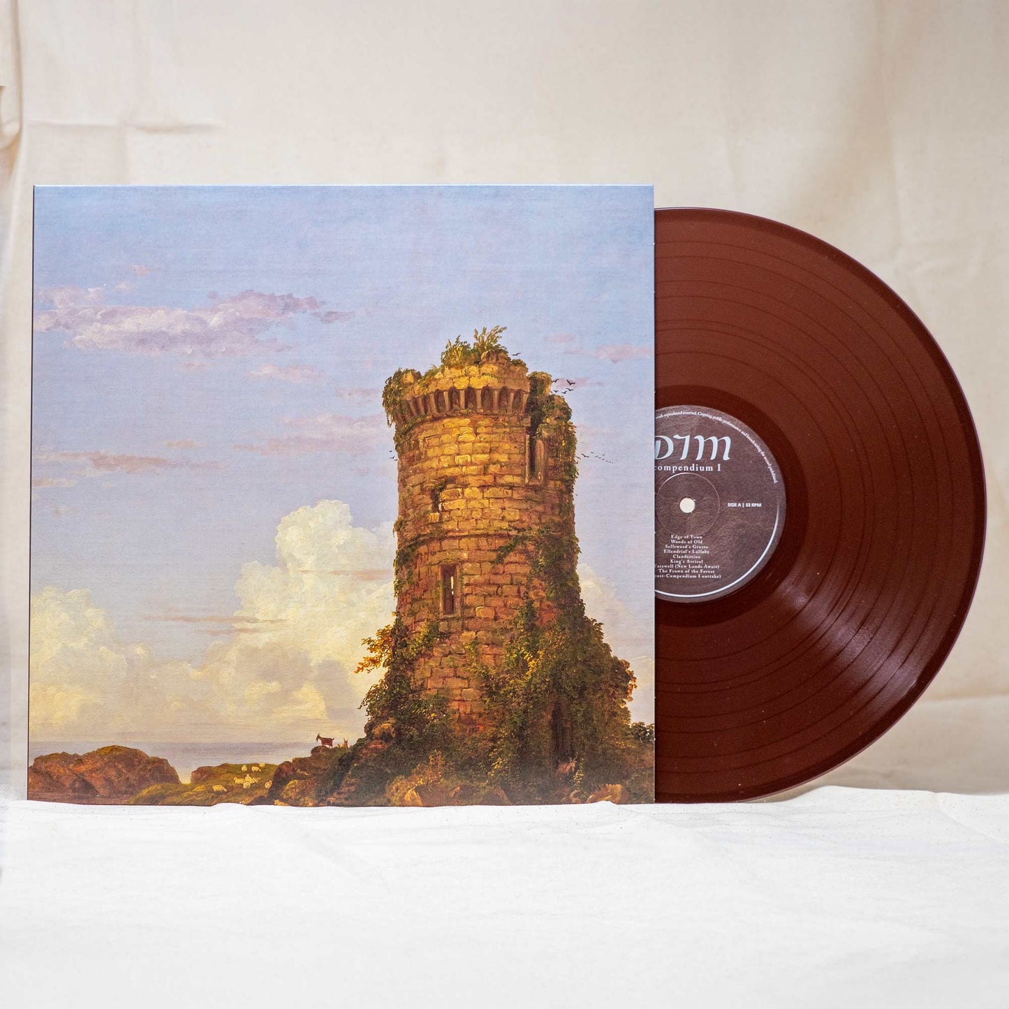 A vinyl record titled 'Compendium I' by DIM with a medieval-themed cover art depicting a tower, on a white background. The vinyl color is brown.