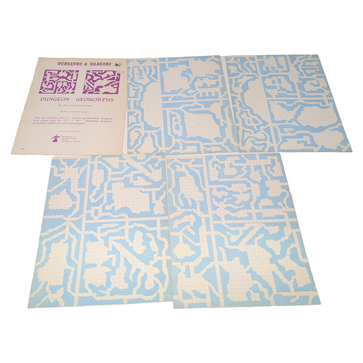 A vintage board game set titled 'Dungeon & Dragons' and 'Dungeon Geomorphs' shown with its instruction booklet and two large game boards featuring a light blue and off-white maze-like grid pattern, photographed on a white background.
