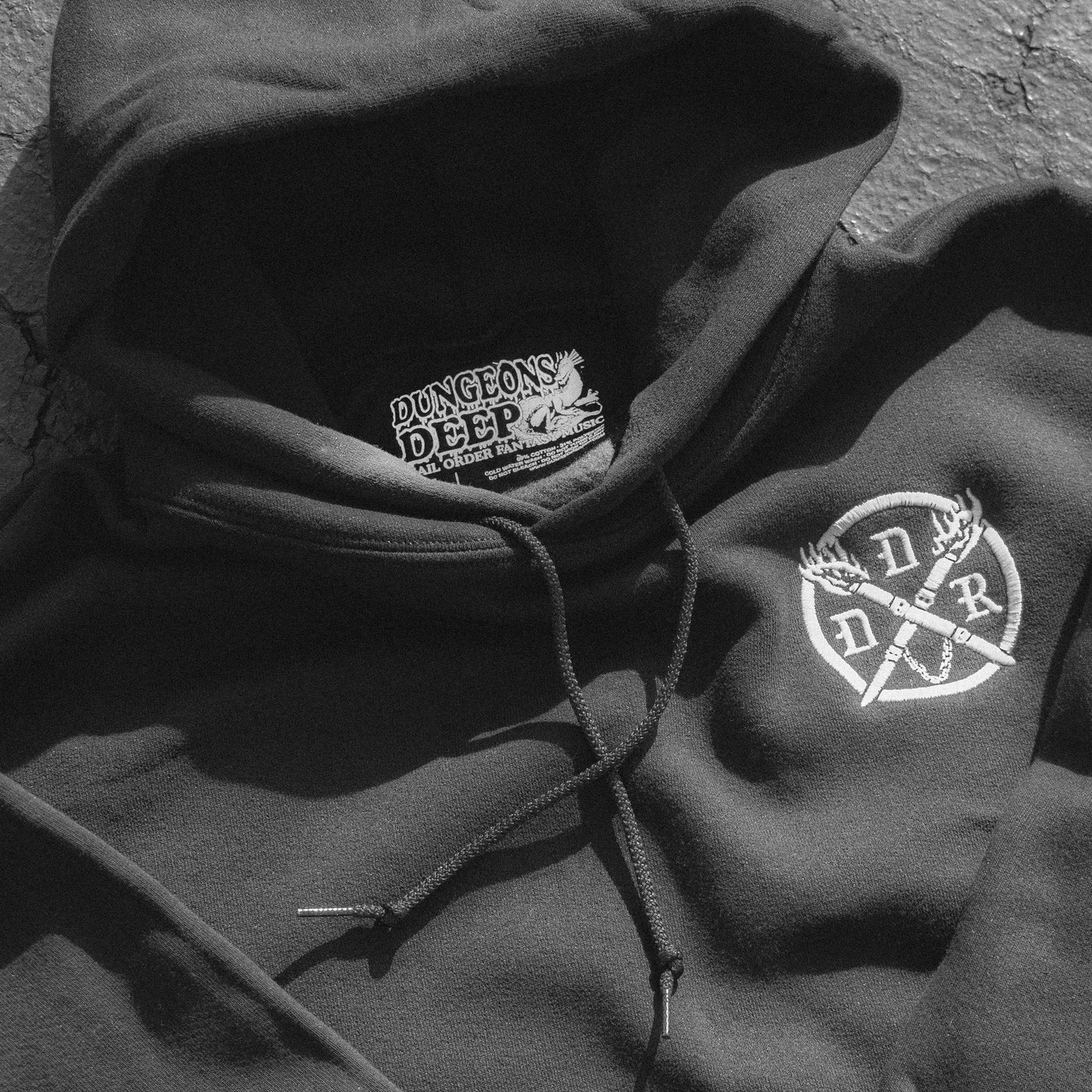 Black hoodie with a white embroidered Dungeons Deep Records emblem on the left chest and 'Dungeons Deep Records' custom tag inside.