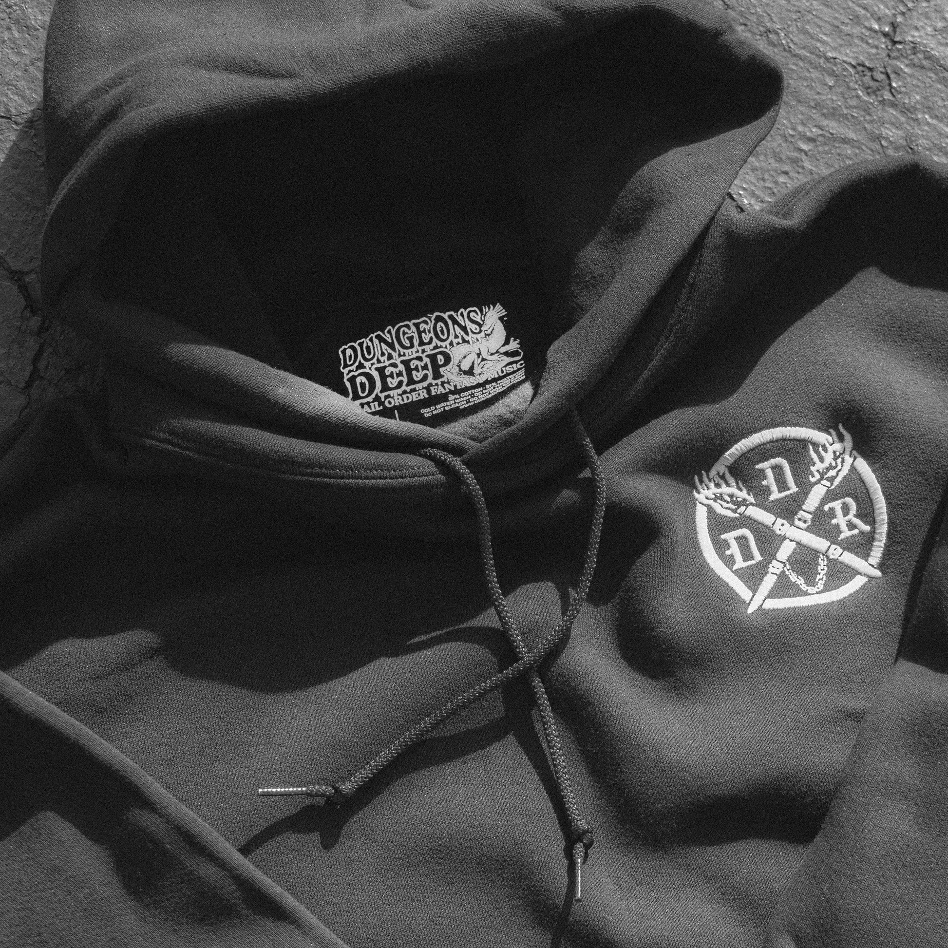 Black hoodie with a white embroidered Dungeons Deep Records emblem on the left chest and 'Dungeons Deep Records' custom tag inside.