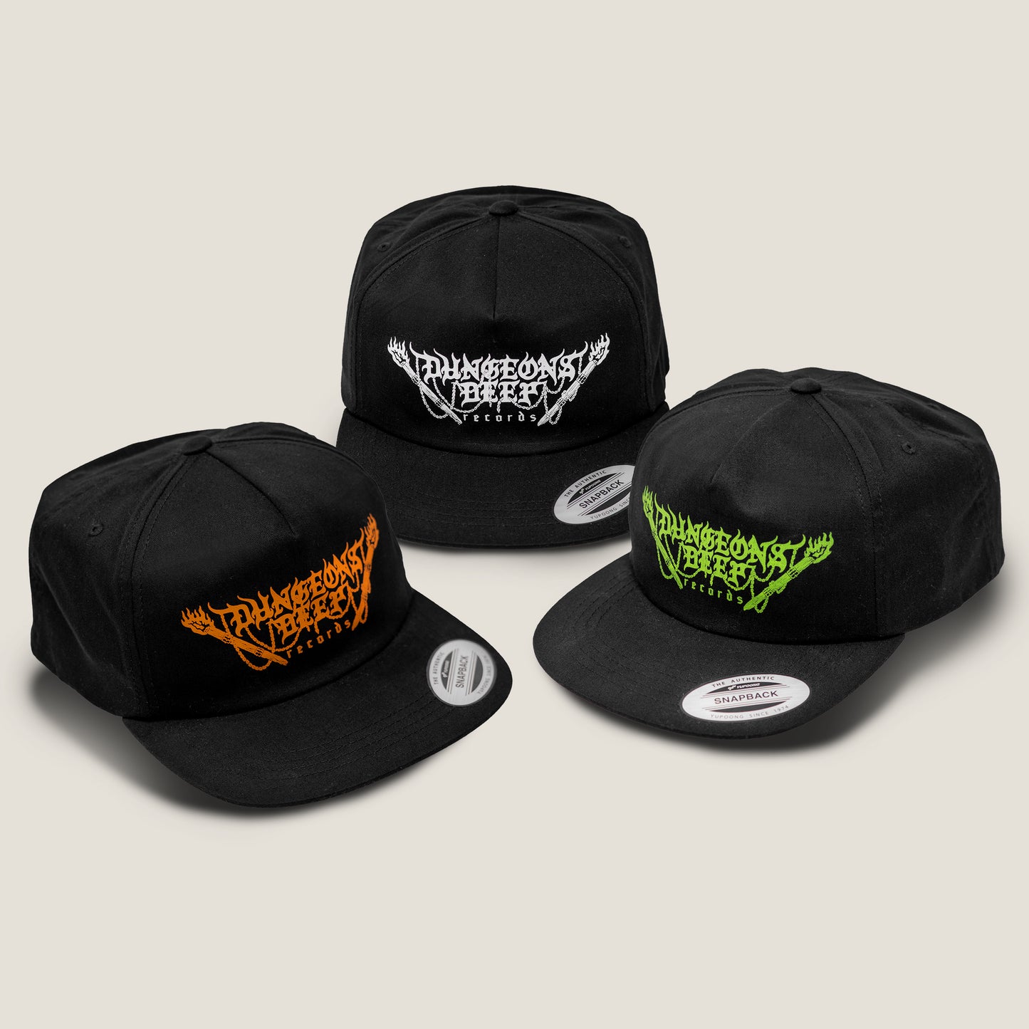 Three black snapback flat billed hats, each of which features the Dungeons Deep Records logo printed in orange, white and green ink.