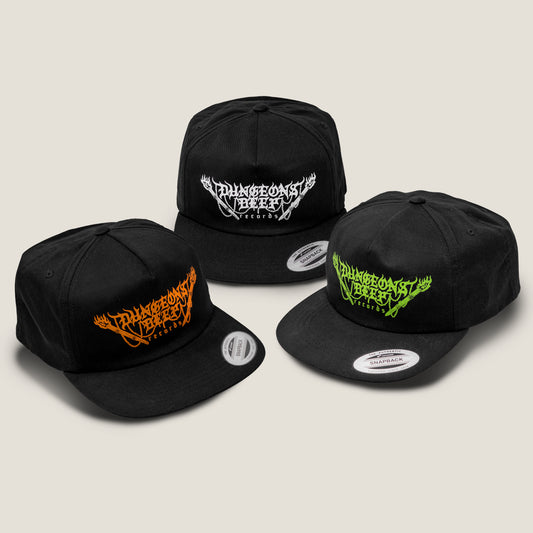 Three black snapback flat billed hats, each of which features the Dungeons Deep Records logo printed in orange, white and green ink.