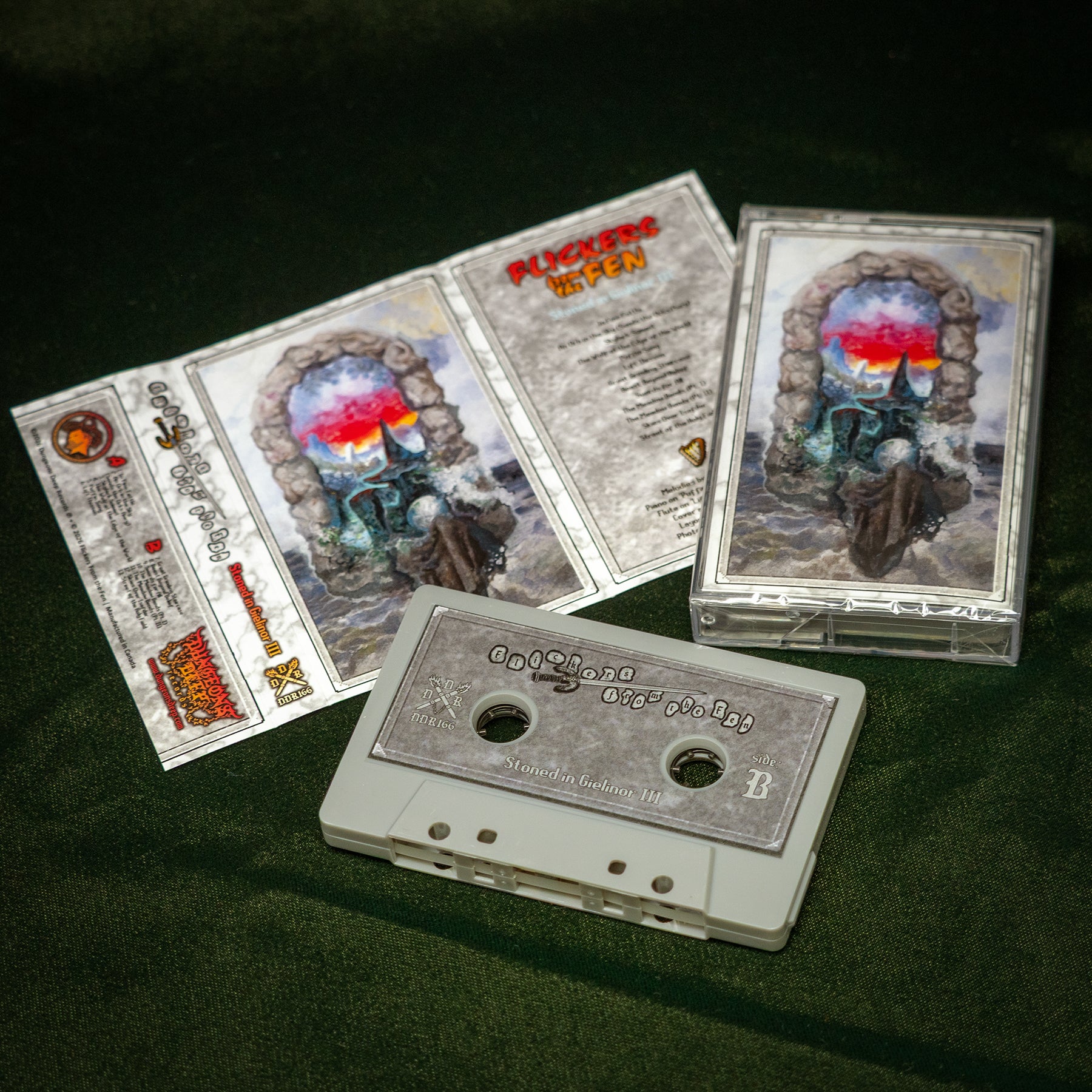 Flickers From the Fen - Stoned in Gielinor II cassette tape album sits on a green velvet background. The cassette tape is grey in color. The album cover shows an image of a wizard emerging from a portal, conjuring a spell.