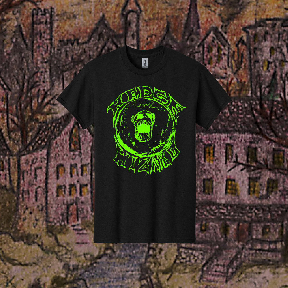 A black t-shirt with a screen printed logo featuring a stylized, glowing green text that reads 'HEDGE WIZARD' and a fantasy-themed illustration of a wizard's face in the center, displayed in front of a medieval-style town and castle background.