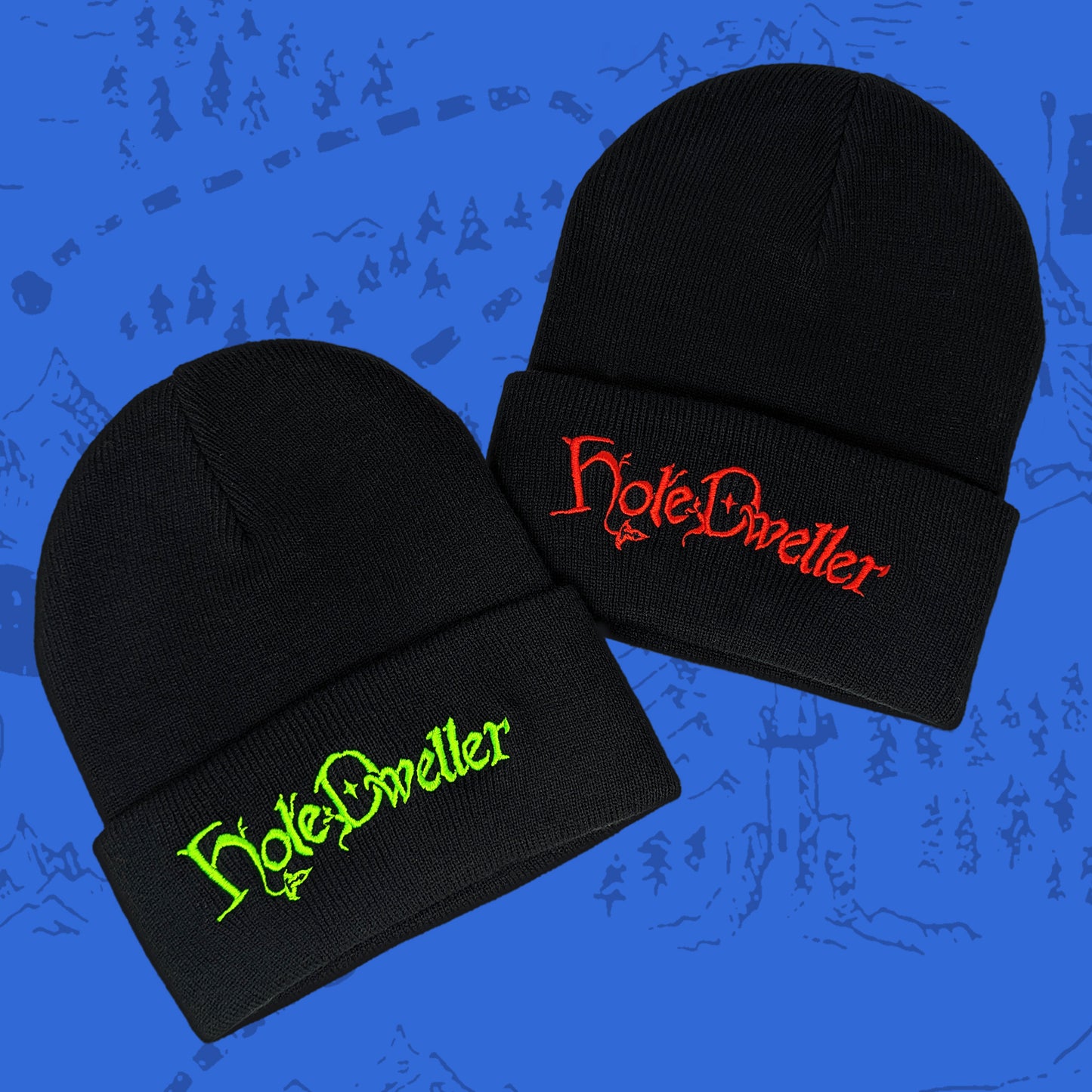 Two black beanies with 'Hole Dweller' text in red and green on a blue background.