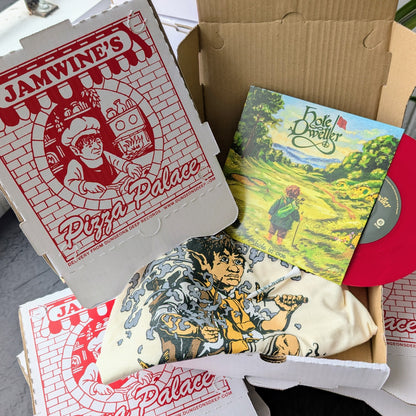 Open pizza box with 'Jamwine's Pizza Palace' branding holding a Hole Dweller T-Shirt, 7" record and golf tee.