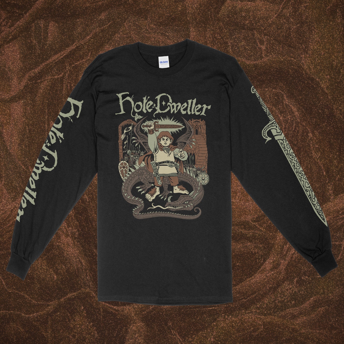 Black long-sleeve Gildan shirt with 'Hole Dweller' graphic design featuring a hobbit holding a sword to the sky. The right sleeve reads Hole Dweller vertically, the left sleeve features a sword. The image is printed in tan, green and brown. The shirt is against a brown textured backdrop. 