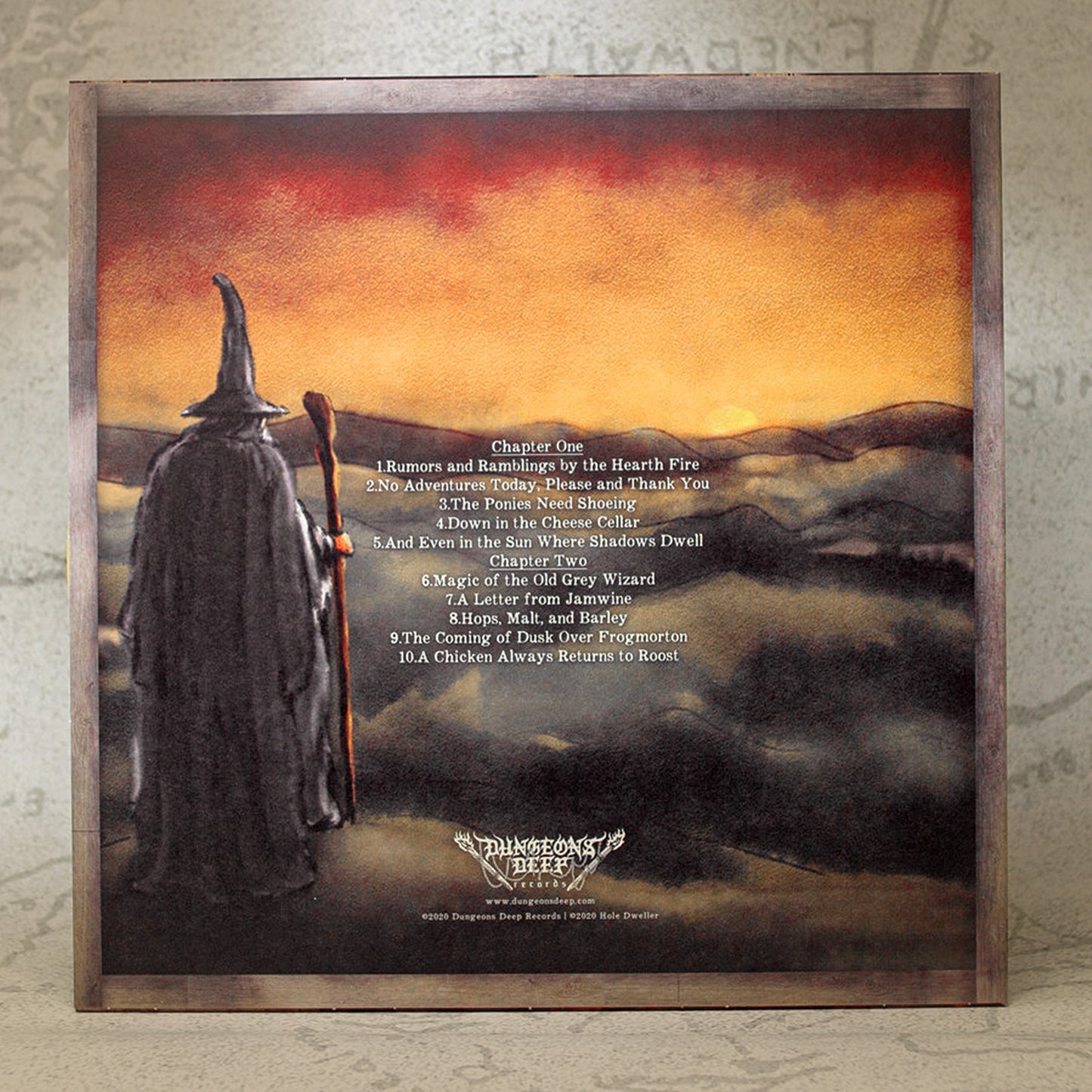 Album cover with a wizard figure and sunset landscape, featuring text on a textured surface.