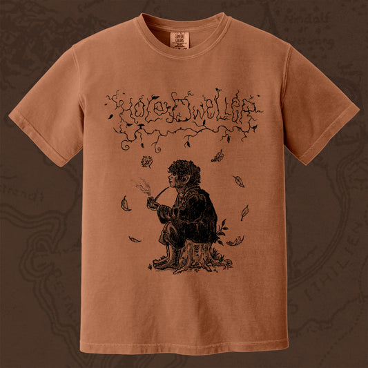 Hole Dweller "flies the coop III" T-Shirt printed in black ink on a dark Orange  shirt. The graphic shows the Hole Dweller logo, and a hobbit sitting on a stump smoking a pipe,