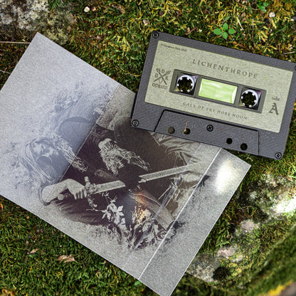 A cassette tape and its sleeve laid on mossy ground. The cassette label reads LICHENTHROPE and Call of the Moss Moon, and the sleeve shows a monochrome illustrated scene with a figure holding a sword.