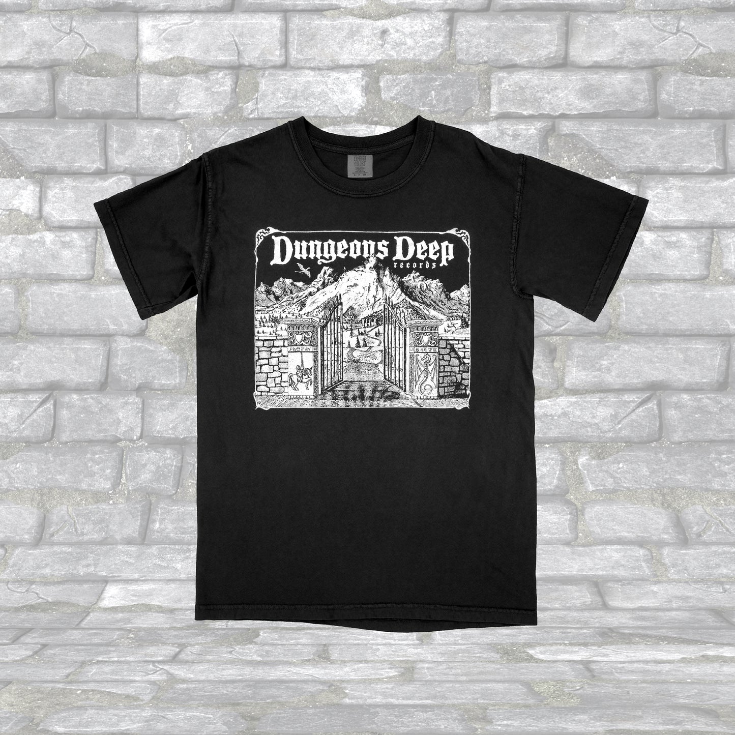 Black T-shirt with 'Dungeons Deep Records' text and a graphic of a a mystical landscape on the front.