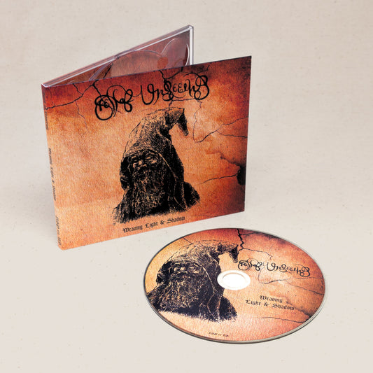 A CD of Spell of Unseeing's Weaving Light and Shadow sitting next to the covering featuring an illustration of a druid.